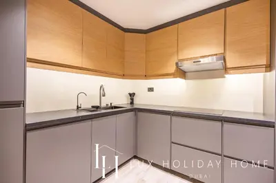 a kitchen with wooden cabinets and a sink at LUX The Contemporary Marina View Suite 7 in Dubai