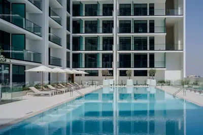 a swimming pool in front of a building at Beautifully Furnished Studio in Binghatti Azure in Dubai