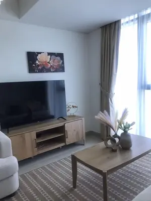 a living room with a television and a coffee table at 2 Bedroom Luxury In Jaddaf in Dubai