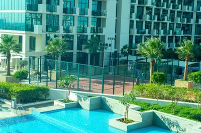 a swimming pool in front of a tall building at 2 Bedroom Luxury In Jaddaf in Dubai