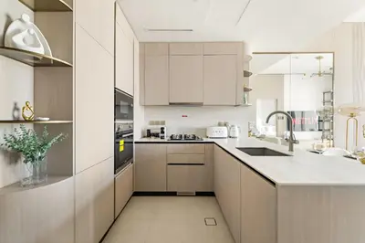 a kitchen with white cabinets and a sink at VayK - Modern & Elegant 1BD in JVC in Dubai