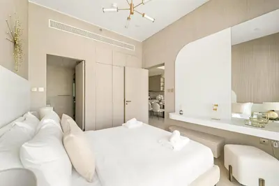 a bedroom with a white bed with white pillows at VayK - Modern & Elegant 1BD in JVC in Dubai