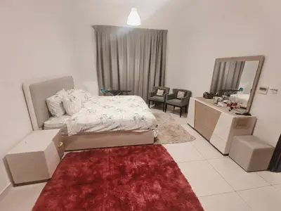 a bedroom with a bed and a vanity and a mirror at Furnished 2 Bedroom Apartment with Balconies in Dubai