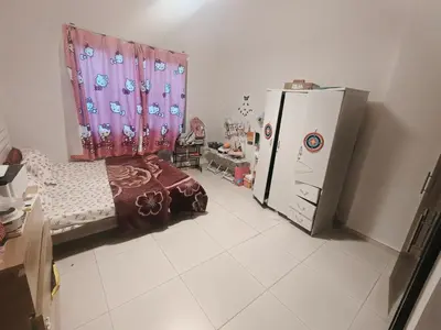 a room with a bed and a refrigerator in it at Furnished 2 Bedroom Apartment with Balconies in Dubai