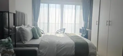 a bedroom with a bed and a large window at Studio in JLT near Metro - Close to Marina, JBR in Dubai