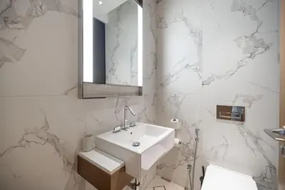 a white bathroom with a sink and a mirror at Address Opera by NAMUVE in Dubai