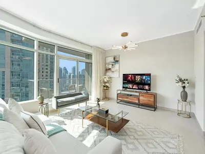 a living room with a couch and a tv at Skyline Upscale 2 Bedroom Apartment I Steps to Burj Khalifa Dubai Fountain Dubai Mall I Mesmerizing Views I Free Gym, Pool, Parking & Wi-Fi in Dubai