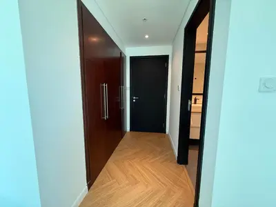 a hallway with a black door and a wooden floor at Luxury Upgraded 2BR in Dubai Marina in Dubai