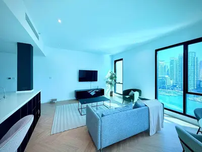 a living room with a couch and a large window at Luxury Upgraded 2BR in Dubai Marina in Dubai