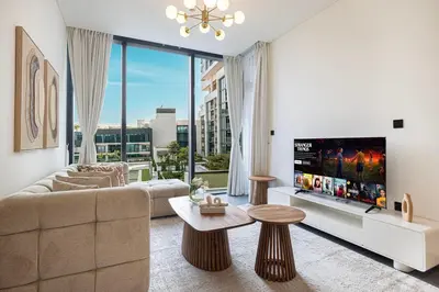 a living room with a couch and a large window at Modern 2 Bedroom Apartment in Sobha Hartland in Dubai
