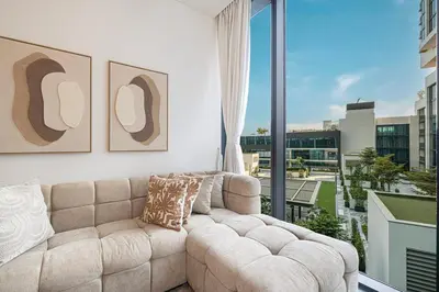 a living room with a couch and a large window at Modern 2 Bedroom Apartment in Sobha Hartland in Dubai