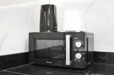 a black microwave oven sitting on top of a counter at Chic 1BR Dubai Marina, 5 Min Walk JBR Beach, Metro in Dubai