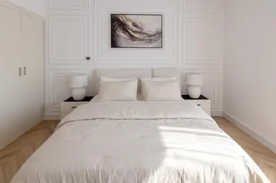 a white bedroom with a large bed with two lamps at Beautiful 1 bed in JBR! in Dubai