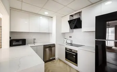 a white kitchen with white cabinets and appliances at Beautiful 1 bed in JBR! in Dubai