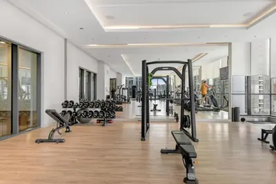 a gym with a lot of treadmills and machines at Two Bedroom in Sobha Waves in Dubai