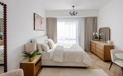 a white bedroom with a bed and a window at Stylish Studio with Marina View JBR in Dubai