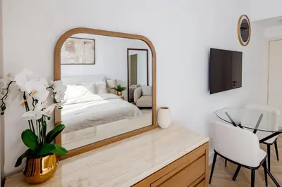 a bedroom with a mirror and a table with a chair at Stylish Studio with Marina View JBR in Dubai