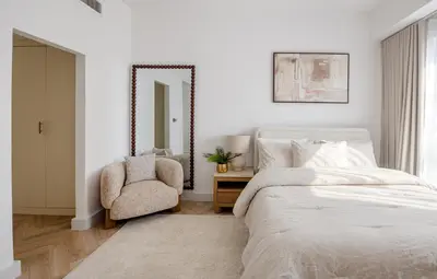 a bedroom with a bed and a chair and a mirror at Stylish Studio with Marina View JBR in Dubai