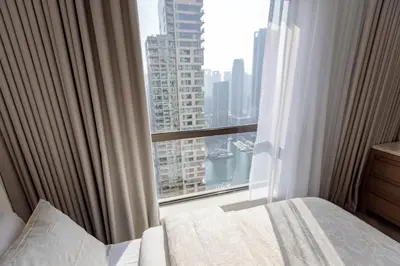 a bedroom with a window with a view of a city at Stylish Studio with Marina View JBR in Dubai