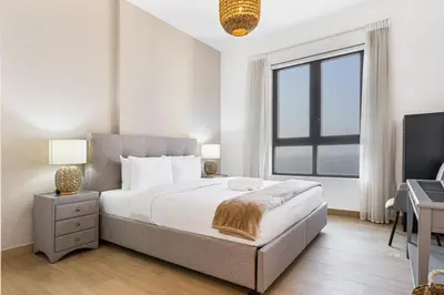 a bedroom with a large bed and a window at Sunny & Stylish 1Bed 7-Min Walk to the Beach! in Dubai