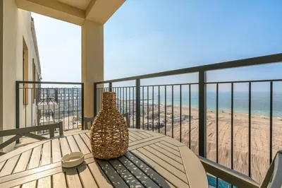 a vase sitting on a table on a balcony overlooking the beach at Sunny & Stylish 1Bed 7-Min Walk to the Beach! in Dubai