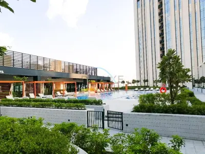 a building with a pool in the middle of a courtyard at Harbour-View 3BR with Assistant Room, Just a Stones Throw from Marine Transportation, Harbour Gate Tower 1, Creek Harbour by Deluxe Holiday Homes in Dubai