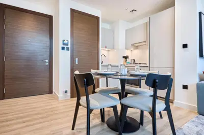 a dining room and kitchen with a table and chairs at STAY BY LATINEM Luxury 1BR Holiday Home CD 0602 Near Burj Khalifa in Dubai