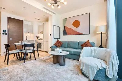 a living room with a blue couch and a table at STAY BY LATINEM Luxury 1BR Holiday Home CD 0602 Near Burj Khalifa in Dubai
