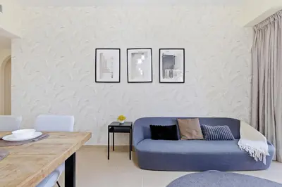 a living room with a blue couch and a table at Rimal 1, JBR - 2 Bedroom Apartment - Allsopp & Allsopp in Dubai