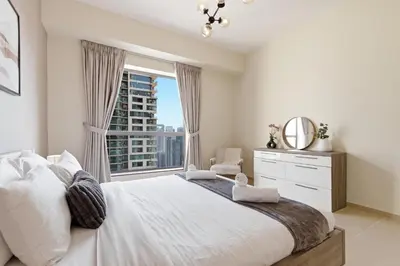 a bedroom with a large bed with a window at Rimal 1, JBR - 2 Bedroom Apartment - Allsopp & Allsopp in Dubai