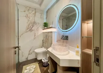 a bathroom with a toilet and a mirror at Brand New Two Bedrooms Apartment With Amazing Marina View in Dubai