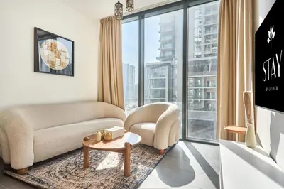 a living room with a couch and a table at STAY BY LATINEM Luxury 1BR Holiday Home CC 0302 Near Burj Khalifa in Dubai