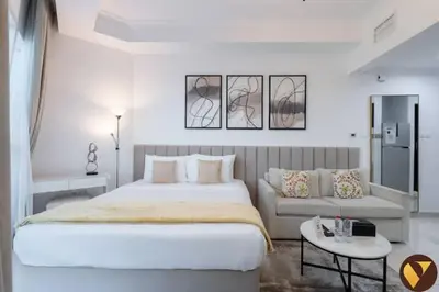 a white bedroom with a large bed and a couch at Vogue Business Bay Court Tower close to Downtown Burj Khalifa and Dubai Mall, Studio Apartment with City view in Dubai