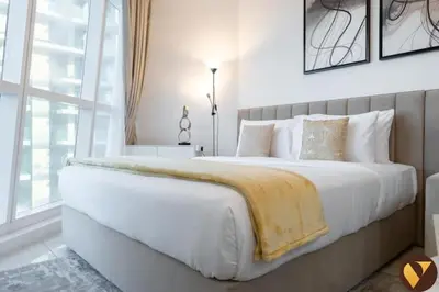 a bedroom with a large white bed with a yellow blanket at Vogue Business Bay Court Tower close to Downtown Burj Khalifa and Dubai Mall, Studio Apartment with City view in Dubai