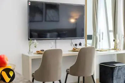 two chairs in front of a desk with a large television at Vogue Business Bay Court Tower close to Downtown Burj Khalifa and Dubai Mall, Studio Apartment with City view in Dubai