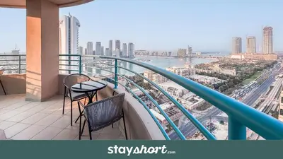 a balcony with two chairs and a view of a city at StayShort - 2 Bedroom in Dubai Marina with Huge Balcony in Dubai