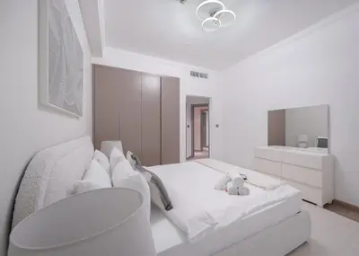 a white bedroom with a bed and a teddy bear at StayShort - 2 Bedroom in Dubai Marina with Huge Balcony in Dubai