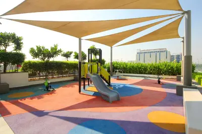 a playground with a slide and an umbrella at Silk Valley - Luxury St with Pool Access & Balcony | 10 Min to Downtown in Dubai