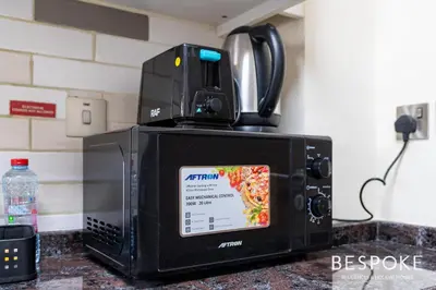 a microwave oven sitting on top of a counter at Bespoke Holiday Homes - Cozy Modern Studio in Samia by Azizi in Dubai