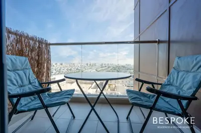 two chairs and a table on a balcony with a view at Bespoke Holiday Homes - Cozy Modern Studio in Samia by Azizi in Dubai