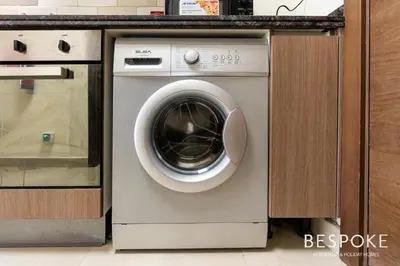 a washing machine in a kitchen next to a counter at Bespoke Holiday Homes - Cozy Modern Studio in Samia by Azizi in Dubai