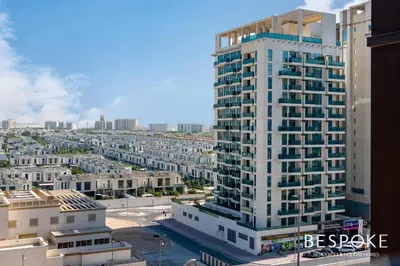 a tall white building in a city with buildings at Bespoke Holiday Homes - Cozy Modern Studio in Samia by Azizi in Dubai