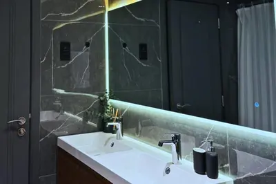 a bathroom with a sink and a large mirror at Luxe 1-BR with Pool Sunset Balcony View in The Greens in Dubai
