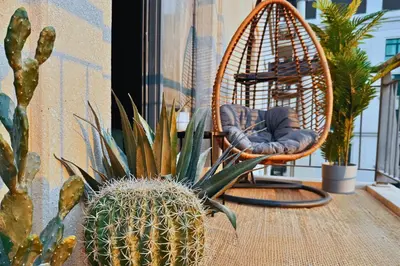 a pineapple sitting next to a chair on a balcony at Luxe 1-BR with Pool Sunset Balcony View in The Greens in Dubai