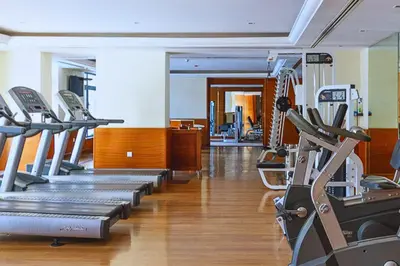 a gym with a row of treadmills and machines at Luxe 1-BR with Pool Sunset Balcony View in The Greens in Dubai