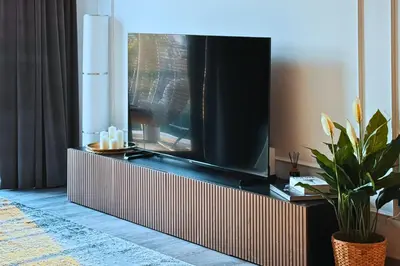 a living room with a large television on a tv stand at Luxe 1-BR with Pool Sunset Balcony View in The Greens in Dubai
