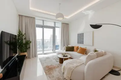 a white living room with a couch and a tv at Imperial Avenue, Downtown Dubai - The Mint Stay in Dubai
