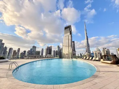 a large swimming pool with a city skyline in the background at Imperial Avenue, Downtown Dubai - The Mint Stay in Dubai