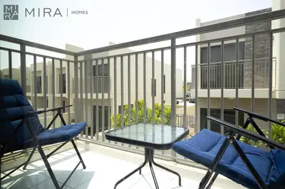 a balcony with a glass table and chairs at Mira Holiday Homes - Spacious 3BDR Villa Stylish & Modern Comfort in Dubai