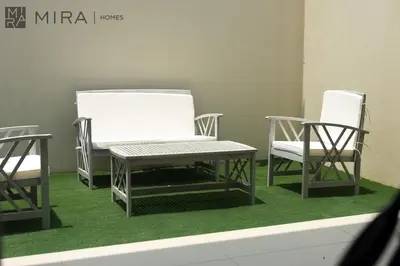 three chairs and a bench on a green carpet at Mira Holiday Homes - Spacious 3BDR Villa Stylish & Modern Comfort in Dubai